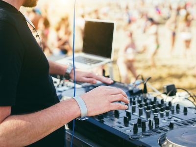 Dj mixing music at beach party during summer event