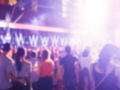 DJ playing and people dancing at the concert, laser show and music